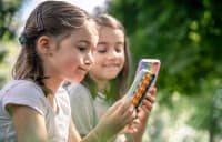 Two little girls on their phones