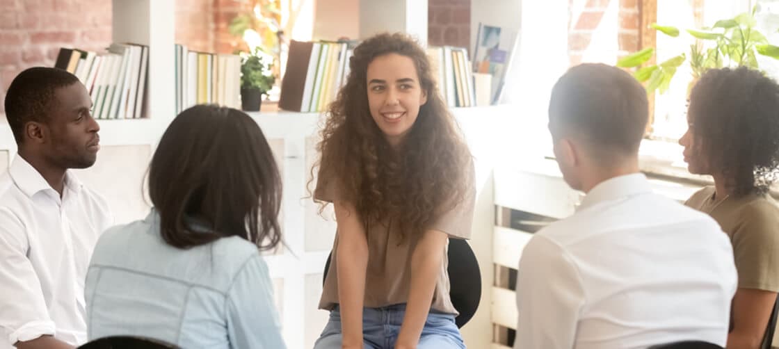 Woman leading a group of people in therapy